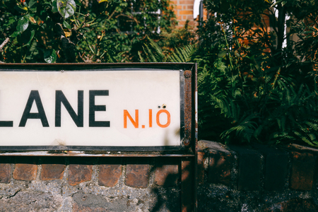 Plastic eyes placed over zero in postcode on the street sign in Muswell Hill, London to make a surprised faceの写真素材