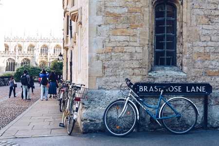 Bicycles parked against the building in Oxford, tourists taking photos on the background. Cycling is a popular way of getting around the city.のeditorial素材