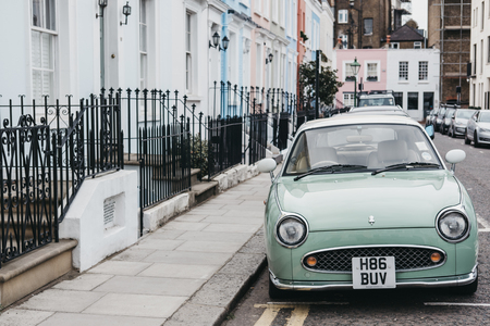 Pastel blue Nissan Figaro next to pastel houses in Notting Hill, London. Nissan Figaro was built for a short period (1991) purely for the Japanese market.のeditorial素材