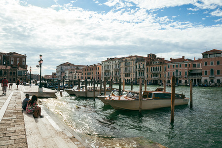 Tourists sit on the steps of Grand Canal. Venice is a popular tourist destination for its uniqueness, art and architecture.のeditorial素材