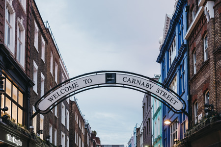 Welcome to Carnaby Street Sign over Carnaby Street. Carnaby Street is a pedestrianised shopping street in Soho area of London.のeditorial素材