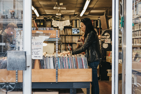 Woman browse vinyl records at a store in Notting Hill, London. Vinyl experiences a renewed interest and increased sales in the past years.のeditorial素材