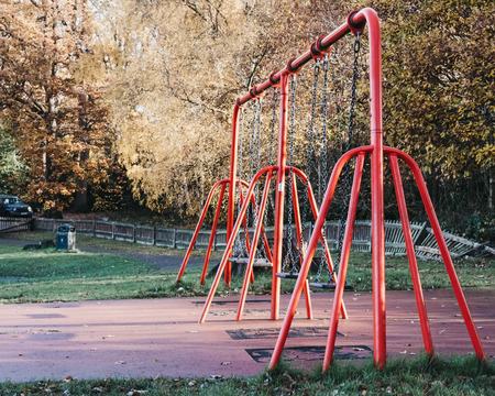 Empty swings in a park on a sunny autumn day