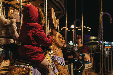 Kids riding merry-go-round at Winter Wonderland, annual Christmas Fair in London, UK.のeditorial素材