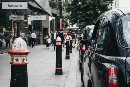 Row of Black cabs parked on a side of the road in City of London, London's famous financial district.のeditorial素材