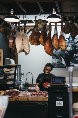Seller packing sausages at a meat stand in Borough Market, one of the largest and oldest food markets in London.のeditorial素材