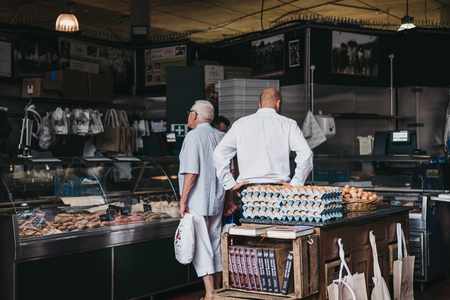 Customers inside a butcher's stand at Borough Market, one of the largest and oldest food markets in London.のeditorial素材
