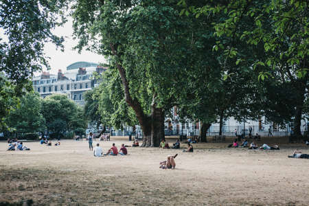 London, UK - July 24, 2018: People relaxing in Lincoln's Inn Fields during summer 2018 heatwave in London, UK. Lincoln's Inn Fields is the largest public square in London.のeditorial素材