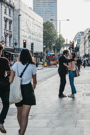 London, UK - July 24, 2018: People kissing in front of passers by on Oxford street, London, one of the most famous streets in the city.のeditorial素材