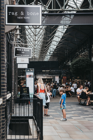 People walking in Spitalfields Market, one of the finest surviving Victorian Market Halls in London with stalls offering fashion, antiques and food.のeditorial素材