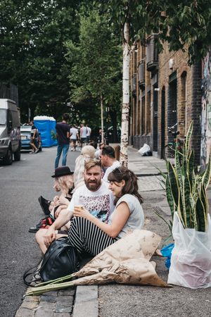People sitting on the ground on Erza Street, relaxing after visiting Columbia Road Flower Market, a street market in East London that is open every Sunday.のeditorial素材