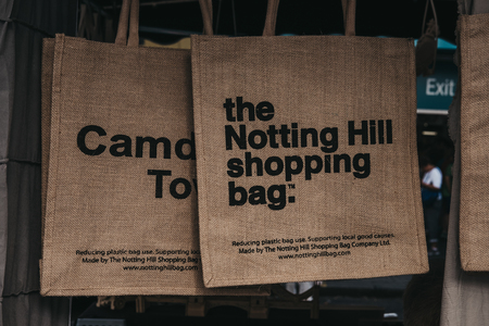 London, UK - July 21, 2018: Jute bag by The Notting Hill Shopping Bag Company on sale at Portobello Road Market. Its images designed by local artists and benefit and promote Notting Hill.のeditorial素材
