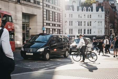 London, UK - September 17, 2018: Businessman on a bicycle waiting for traffic to pass on a street in the City of London, London, UK, London's famous financial district.のeditorial素材