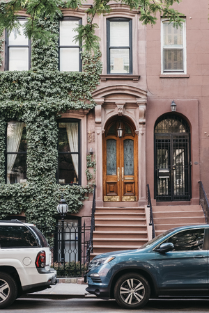 New York, USA - May 30, 2018: Facade of a typical New York house with a stoop, cars park outside. Stoops wereoriginally brought to the Hudson Valley of New York by settlers from the Netherlands.のeditorial素材