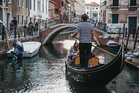 Venice, Italy - July 01, 2017: Gondola with tourists on a narrow canal in Venice, Italy. Boats are the main mode of transport in the city.のeditorial素材