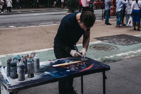 New York, USA - May 28, 2018: Street artist creating a picture for sale using with spray paint in Times Square, one of New York's most famous tourist attractions.のeditorial素材