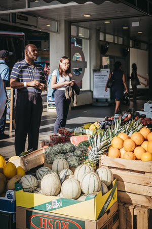 London, UK - August 1, 2018: People buying fresh fruit at a stall outside Hampstead Heath Rail Station, London. Hampstead is an affluent area favoured by academics, artists and media figures.のeditorial素材