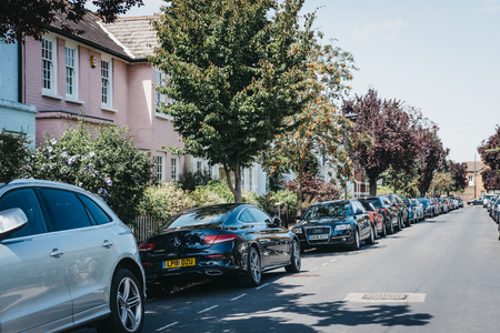 London, UK - August 1, 2018: Cars parked by colourful pastel houses in Barnes, London. Barnes is an affluent residential area of London famous for its village atmosphere.のeditorial素材