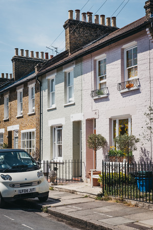 London, UK - August 1, 2018: Car parked by colourful pastel houses in Barnes, London. Barnes is an affluent residential area of London famous for its village atmosphere.のeditorial素材