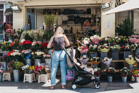 London, UK - August 1, 2018. Woman buying flowers from a florist in Richmond, a suburban town in south-west London famous for large number of parks and open spacesのeditorial素材