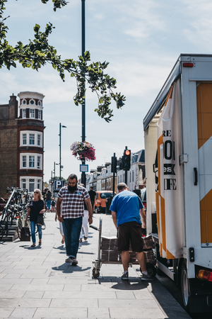 London, UK - August 1, 2018: Man unloading Evening Standard newspaper from a van in Richmond. Evening Standard is a local, free daily newspaper, published Monday to Friday in tabloid format in London.のeditorial素材