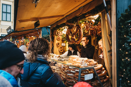 Vienna, Austria - November 25, 2018: People buying pretzels on sale at Christmas and New Year's Market at SchÃ¶nbrunn Palace, one of the most important architectural monuments in Austria.のeditorial素材