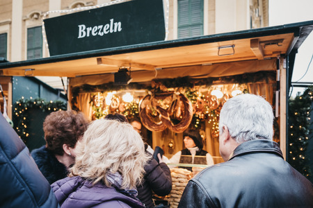 Vienna, Austria - November 25, 2018: Rear view of people queuing to buy pretzels at Christmas and New Year's Market at SchÃ¶nbrunn Palace, one of the most important architectural monuments in Austria.のeditorial素材