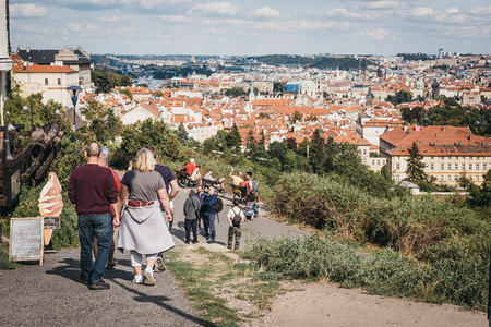 Prague, Czech Republic - August 26, 2018: Group of tourists walking down a path overlooking rooftops of Prague's Lesser Town, one of the city's most historic regions.のeditorial素材