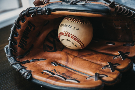London, UK - January 3, 2019: Close up of a white baseball ball inside tan baseball glove. Originating in England in 18th century, baseball is a widely popular sport in many countries worldwide.のeditorial素材