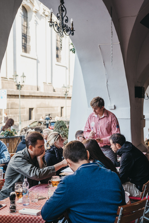 Prague, Czech Republic - August 23, 2018: People drinking beer at the outdoor tables of a Czech restaurant in Prague. Beer is a large part of Czech culture.のeditorial素材