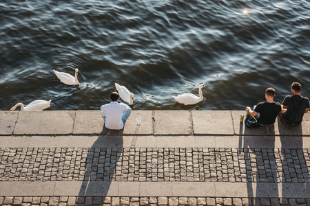 Prague, Czech Republic - August 23, 2018: People sitting on the embankment of Vltava river in Prague on a warm summer day. Vltava is the longest river within the Czech Republic.のeditorial素材