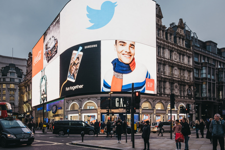 London, UK - January 5, 2019: People walking in front of big digital screens in Piccadilly Circus,...