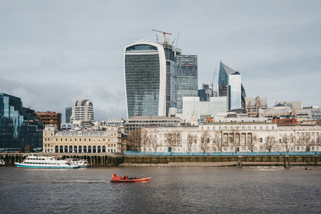 London, UK - January 13, 2019: City cruise boats on the Thames, modern futuristic looking offices on the background. River cruises are very popular with tourists all year around.のeditorial素材