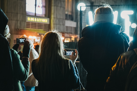 London, UK - January 26, 2019: People talking photos of a sign at Winter Lights, yearly lights and installations festival in Canary Wharf, a busy financial area of London that often host events.のeditorial素材