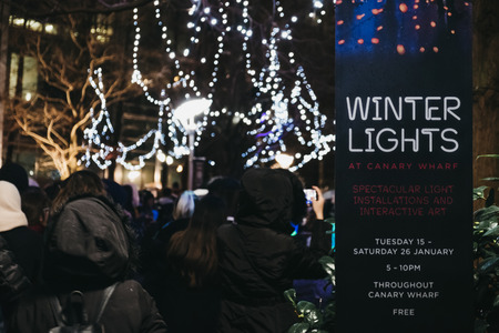 London, UK - January 26, 2019: People walking inside Winter Lights, yearly lights and installations festival in Canary Wharf. Canary Wharf is a busy financial area of London that often host events.のeditorial素材
