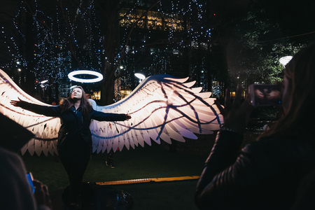London,UK-January 26, 2019: Woman posing for photo in Winter Lights, yearly lights and installations festival in Canary Wharf. Canary Wharf is a busy financial area of London that often host events.のeditorial素材