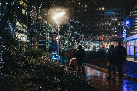 London, UK - January 26, 2019: People walking inside Winter Lights, yearly lights and installations festival in Canary Wharf. Canary Wharf is a busy financial area of London that often host events.のeditorial素材