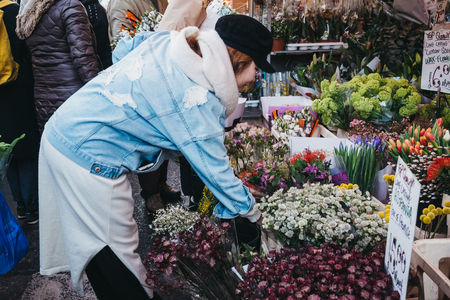London, UK - February 3, 2019: People buying flowers from a market stalls at Columbia Road Flower Market, a street market in East London that is open every Sunday.のeditorial素材
