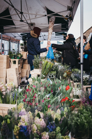 London, UK - February 3, 2019: People buying flowers from a market stalls at Columbia Road Flower Market, a street market in East London that is open every Sunday.のeditorial素材