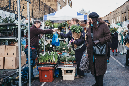 London, UK - February 3, 2019: People buying flowers from a market stalls at Columbia Road Flower Market, a street market in East London that is open every Sunday.のeditorial素材