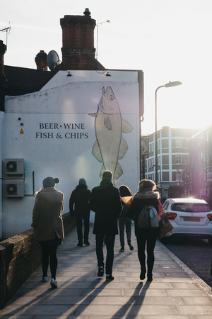 London, UK - February 03, 2019: People walking on a street in East London with flowers purchased at the Columbia Road Flower Market, a street market in East London that is open every Sunday.のeditorial素材