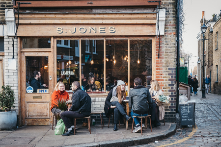 London, UK - February 03, 2019: People sitting outside S. Jones cafe on Erza Street, relaxing after visiting Columbia Road Flower Market, a street market in East London that is open every Sunday.のeditorial素材