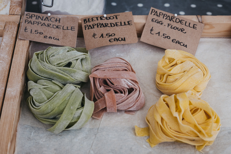 Variety of fresh artisan pappardelle pasta on sale at a street market.の写真素材