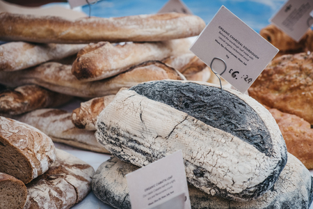 Fresh artisan charcoal bread on sale at a street market, selective focus.