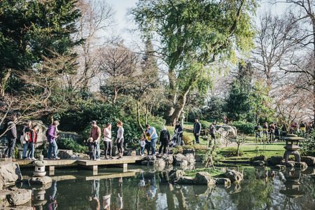 London, UK - February 23, 2019: People walking inside Kyoto Garden in Holland Park on a sunny spring day. Kyoto Garden, a Japanese garden, was donated by the Chamber of Commerce of Kyoto in 1991.のeditorial素材
