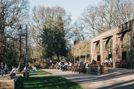 London, UK - February 23, 2019: People relaxing inside Holland Park, London, on a sunny spring day. Holland park is the largest park in Kensington and Chelsea borough with 22.5 hectares of gardens.のeditorial素材