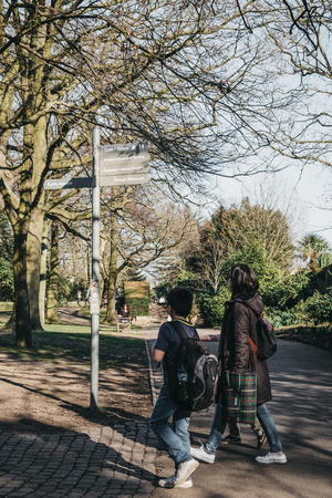 London, UK - February 23, 2019: People walking inside Holland Park, London, on a sunny spring day. Holland park is the largest park in Kensington and Chelsea borough with 22.5 hectares of gardens.のeditorial素材