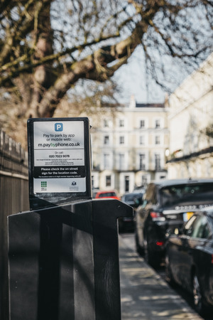 London, UK - February 23, 2019: Parking instructions on a parking meter on a street in Holland Park, The Royal Borough of Kensington and Chelsea. Holland Park is an affluent area in West London.のeditorial素材
