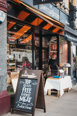 London, UK - March 2, 2019: Sign and employee at a stall outside Hampstead Butchers in Hampstead, an affluent area of London favoured by academics, artists and media figures.のeditorial素材