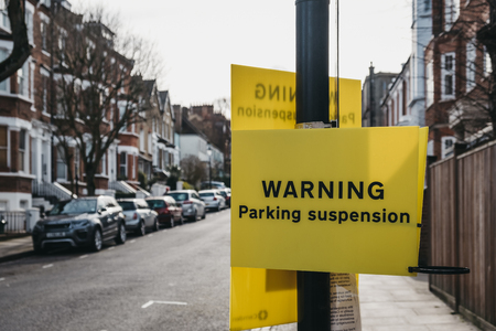 London, UK - March 2, 2019: Yellow warning parking suspension sign on a residential street in Hampstead, an affluent residential area of London favoured by artists and media figures.のeditorial素材
